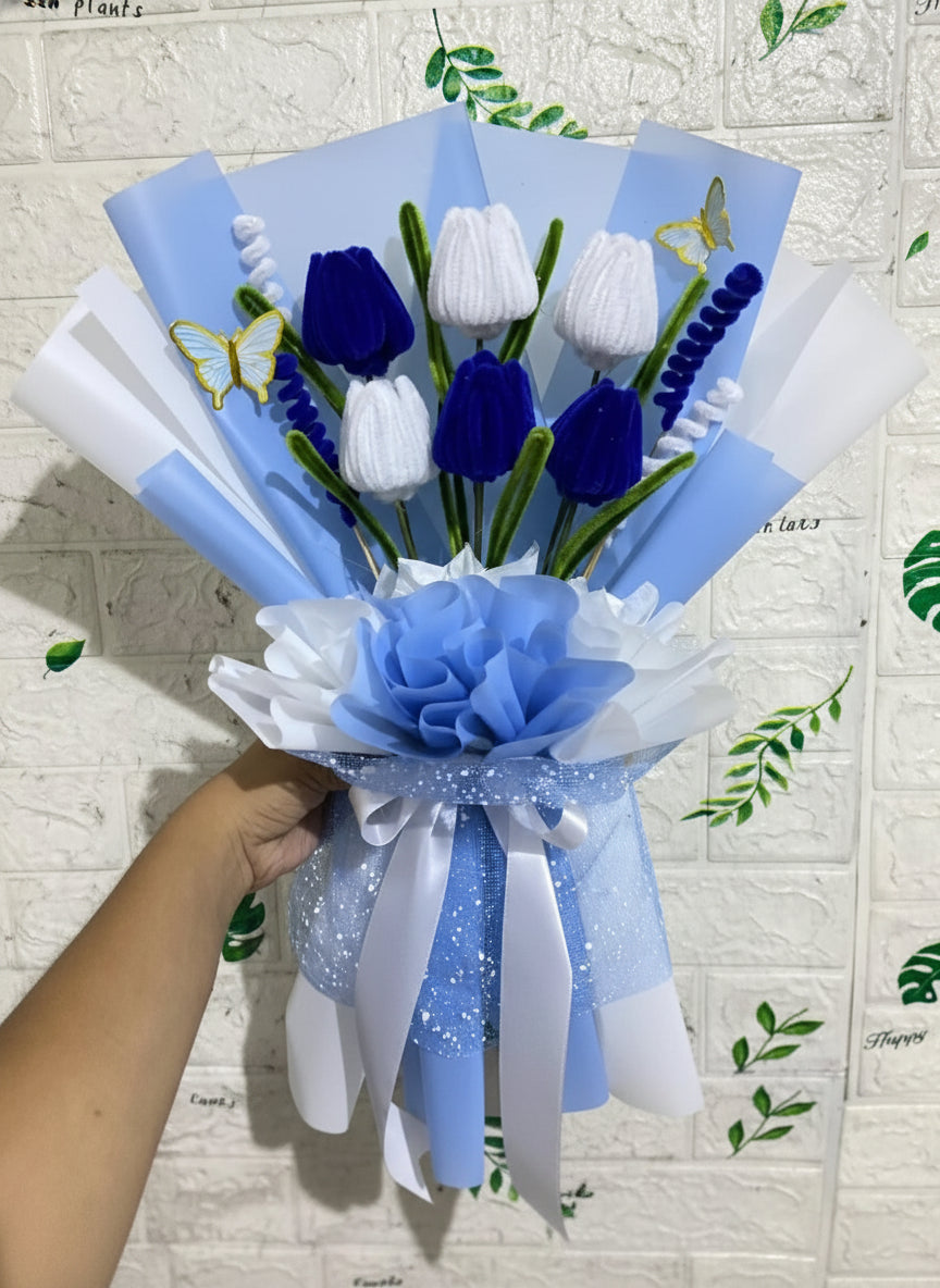 Bouquet of blue and white flowers with decorative ribbons on a textured wall background