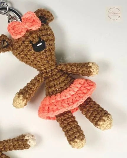 Crocheted reindeer keychain with pink bow on a white background