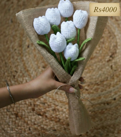 Bouquet of white crocheted tulips wrapped in burlap with a price tag of Rs 4000.